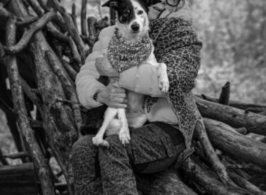Border-Collie-Mix Motzi mit ihrem Frauchen in schwarz-weiß black and white im Wald sitzend auf einem Baumstamm. Perfekt für mich als Hundefotograf in der Nähe und ein Fotoshooting Hund draußen outdoor in der Natur.